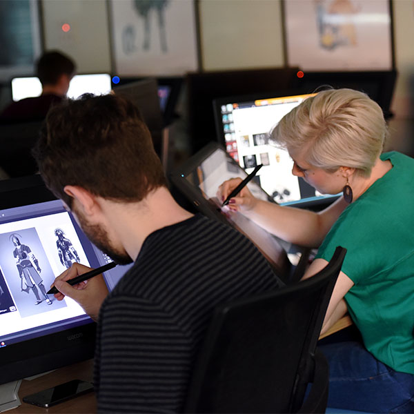 Students in a workshop using drawing tablets